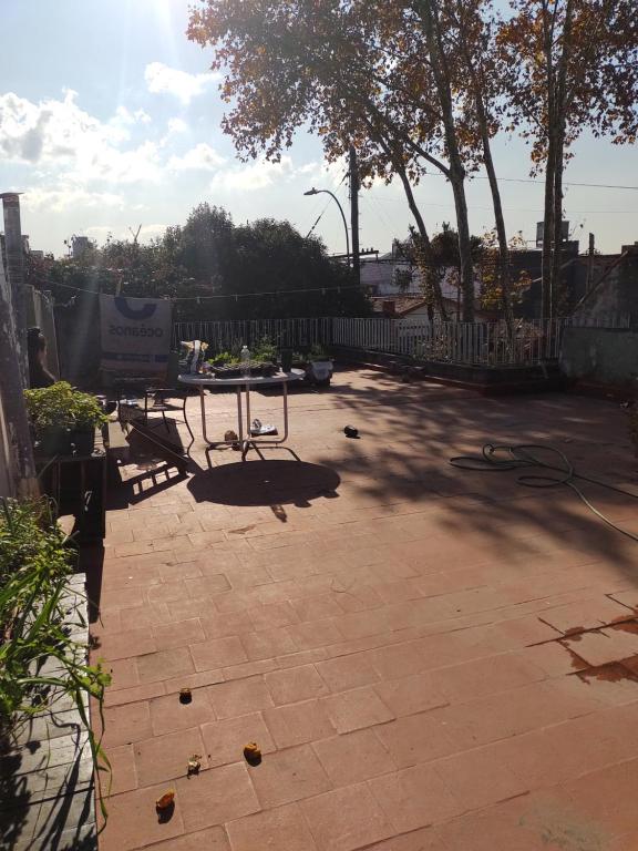un patio con una valla, una mesa y bancos en Casa del Arbol en Presidente Roque Sáenz Peña