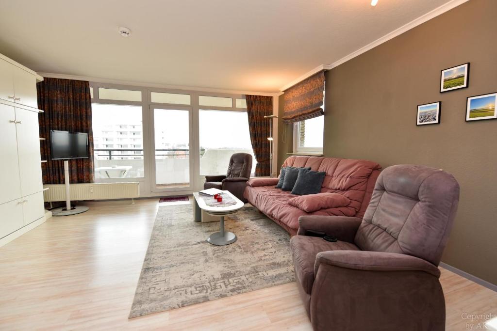 a living room with a couch and a tv at Haus "Panorama" Appartement PAN069 in Duhnen