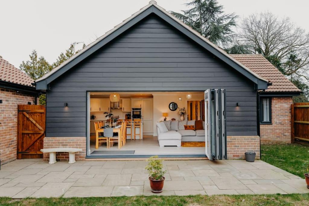 a black house with a living room and a patio at Cottage in the Heart of Suffolk in Stowmarket