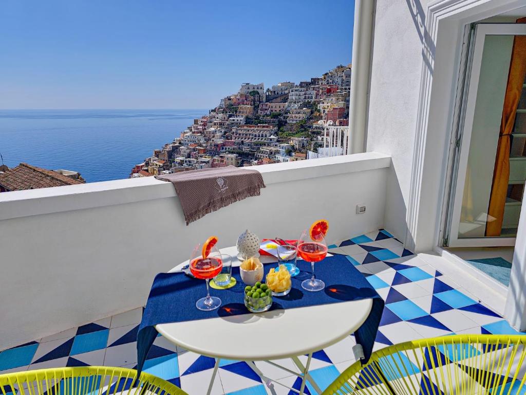 a table on a balcony with a view of the ocean at La Pigolina in Positano