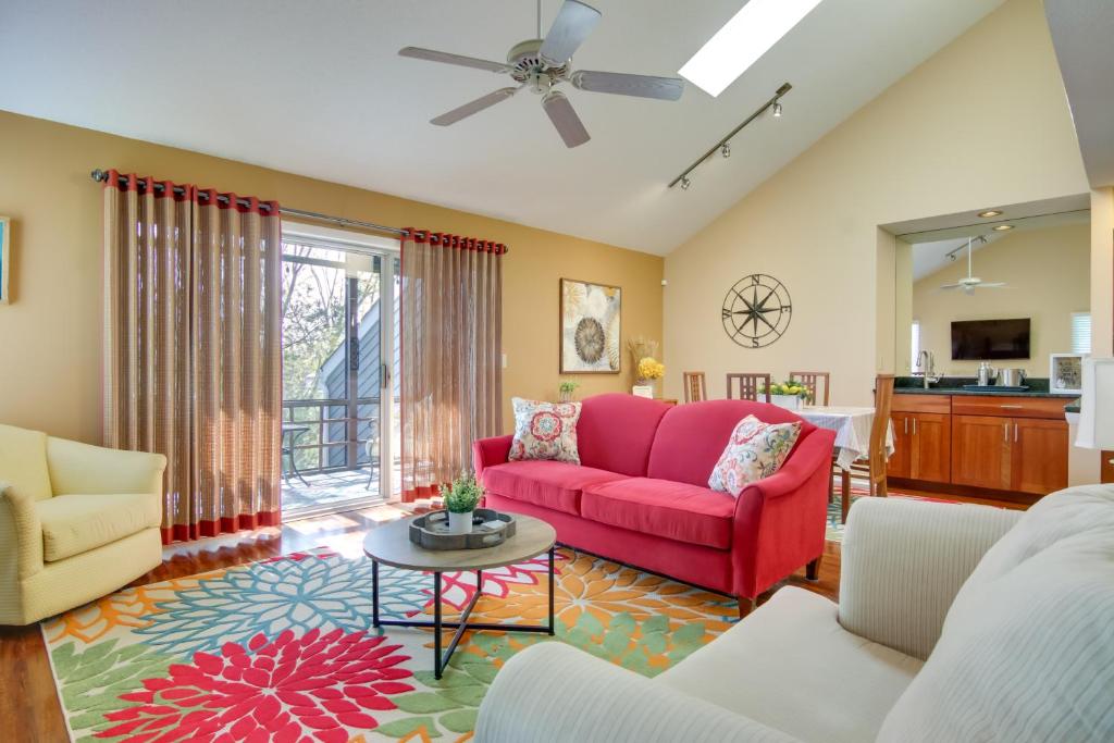a living room with a red couch and a table at Condo with 2 Balconies and 3 Pools Less Than 2 Mi to Beach! in Rehoboth Beach