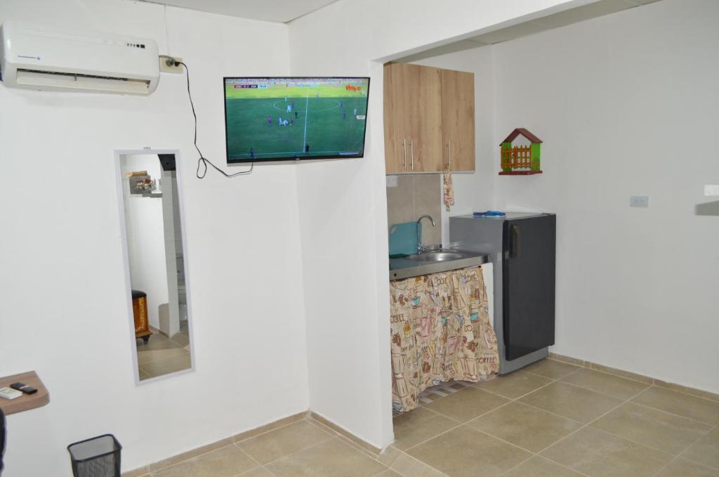 a kitchen with a tv on a wall at Apartaestudio buenos aires in Barrancabermeja