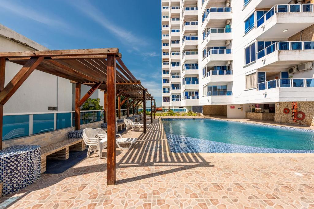 a swimming pool next to a tall building at Apartamento Nuevo Conquistador in Cartagena de Indias