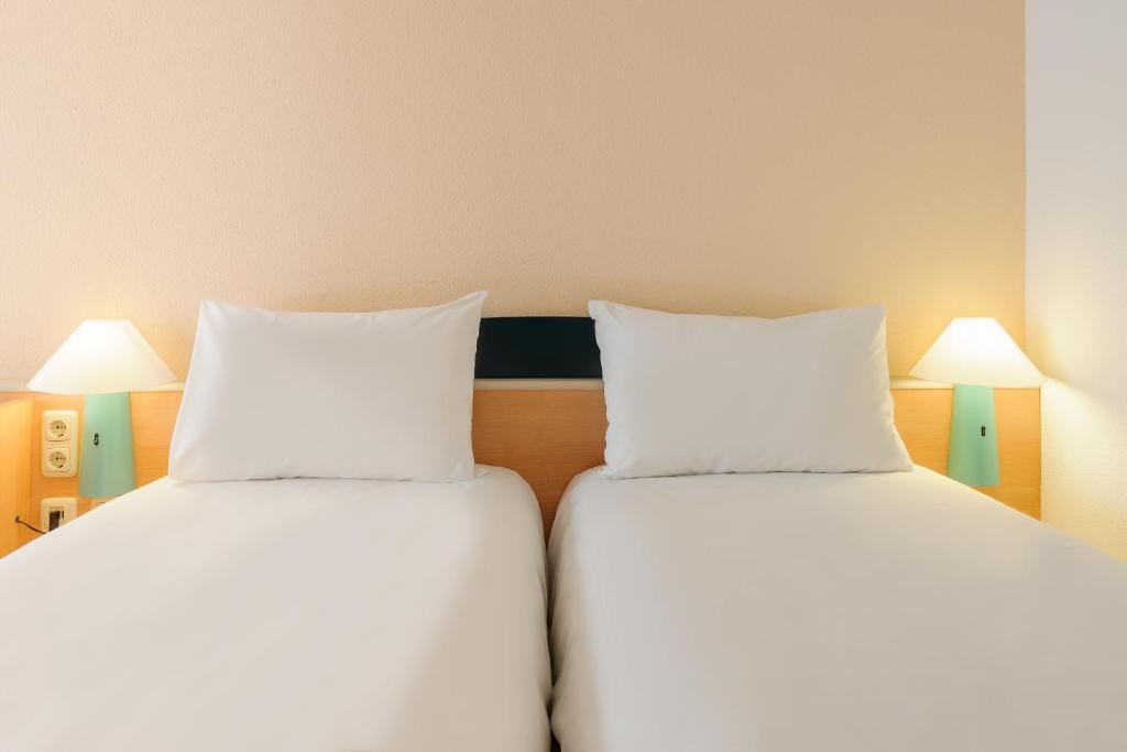 Postel nebo postele na pokoji v ubytování ibis Bamberg Altstadt