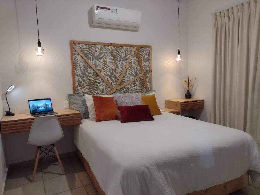 een slaapkamer met een bed en een laptop op een bureau bij Departamento en renta Cabos San lucas in Cabo San Lucas