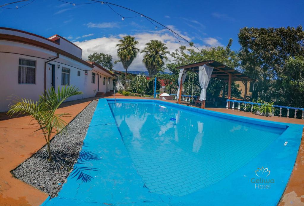 a swimming pool in front of a house at Geliwa B&B in Turrialba