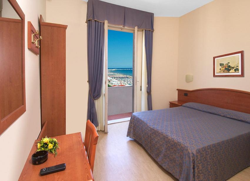 1 dormitorio con cama, mesa y ventana en Hotel Argentina, en Senigallia