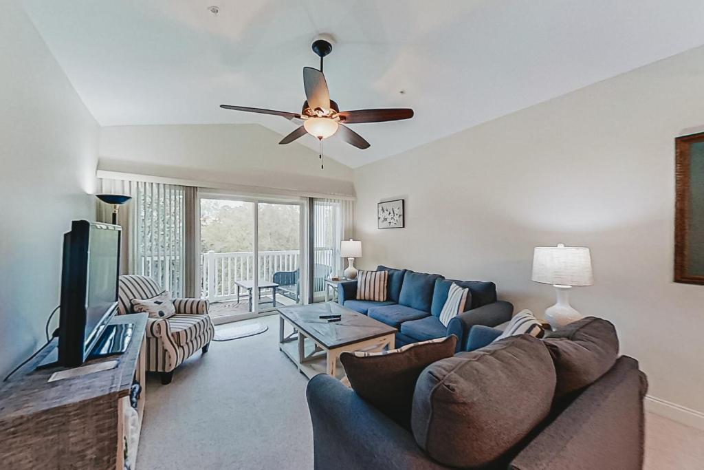 een woonkamer met een bank en een plafondventilator bij World Tour Retreat in Myrtle Beach