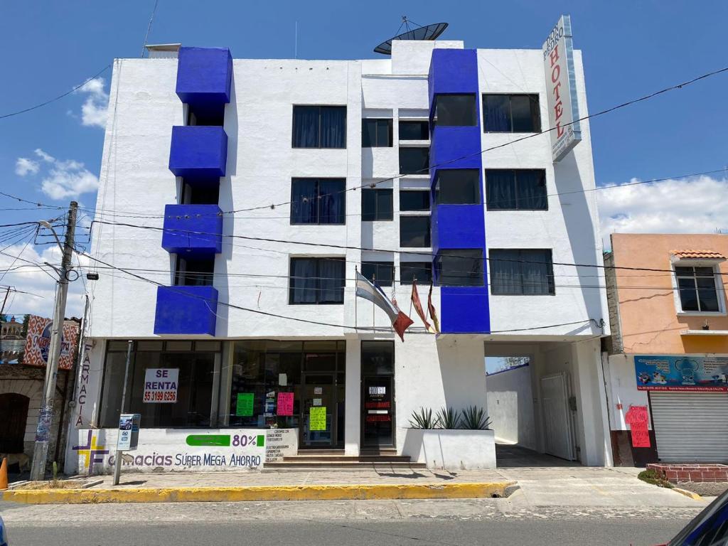 a white building with blue boxes on it at Hotel Don Pedro Centro in Villa de Tamazulapan