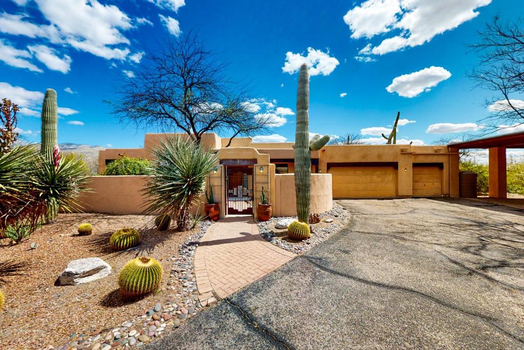 a home in the desert with a palm tree in the driveway at Saguaro Sanctuary in Tucson