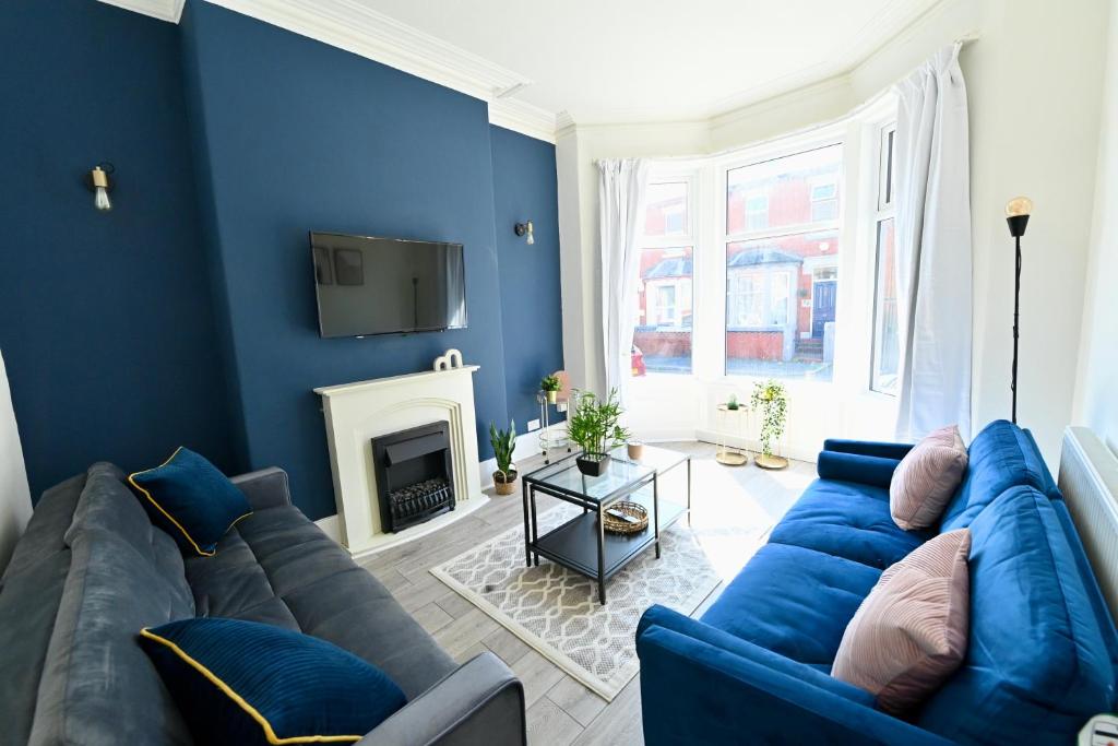 a living room with blue walls and a blue couch at Kingdom Lodgings in Blackpool