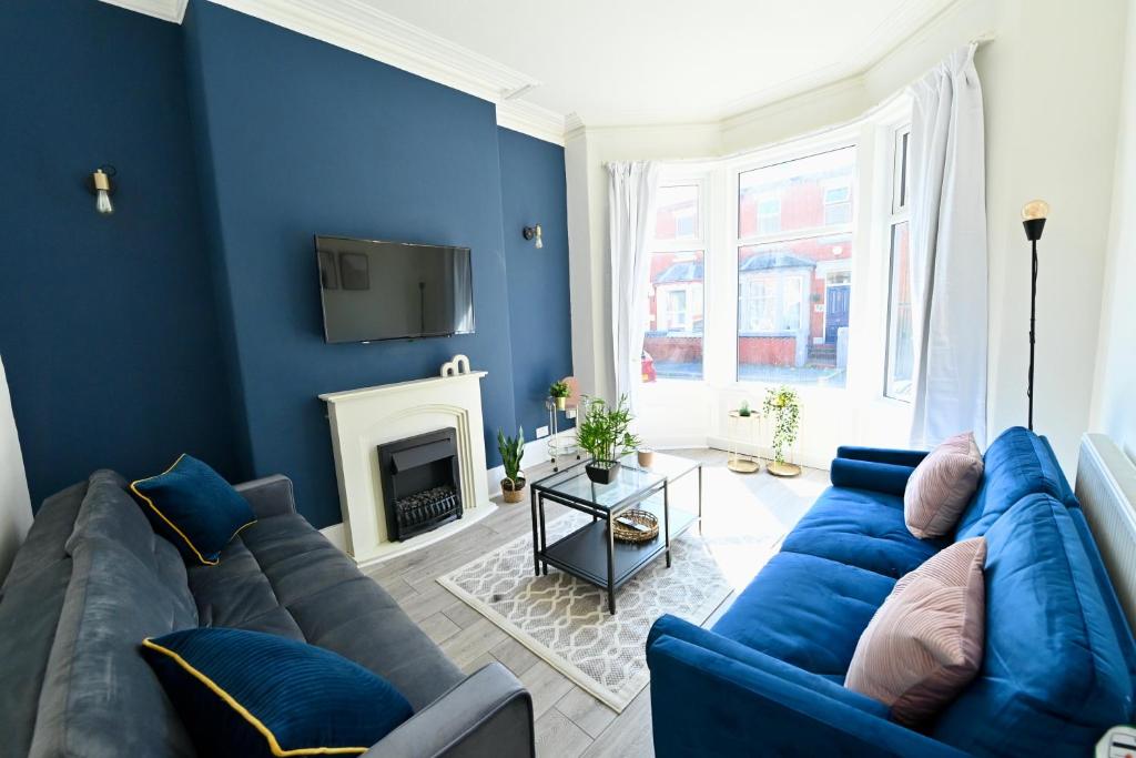 a living room with blue walls and a blue couch at Manchester House in Blackpool