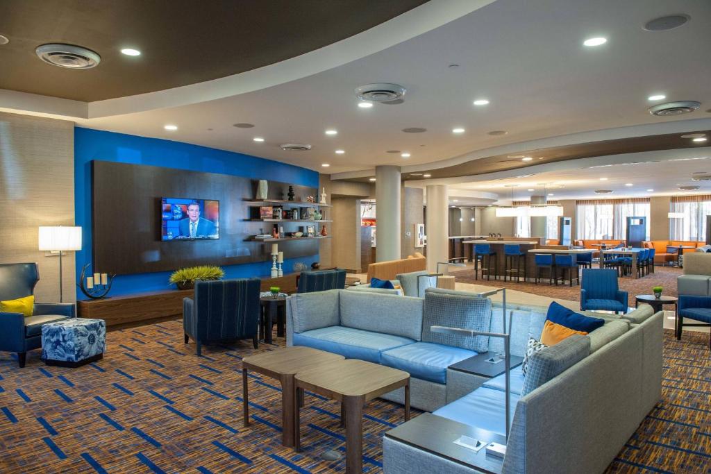 a hotel lobby with couches and a tv and tables at Courtyard by Marriott Pensacola Downtown in Pensacola