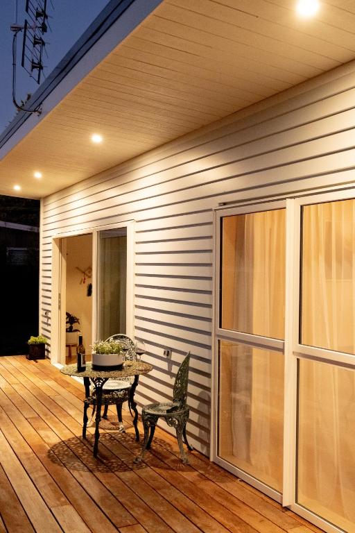 a wooden deck with a table and bench on a house at The Castle in Greytown