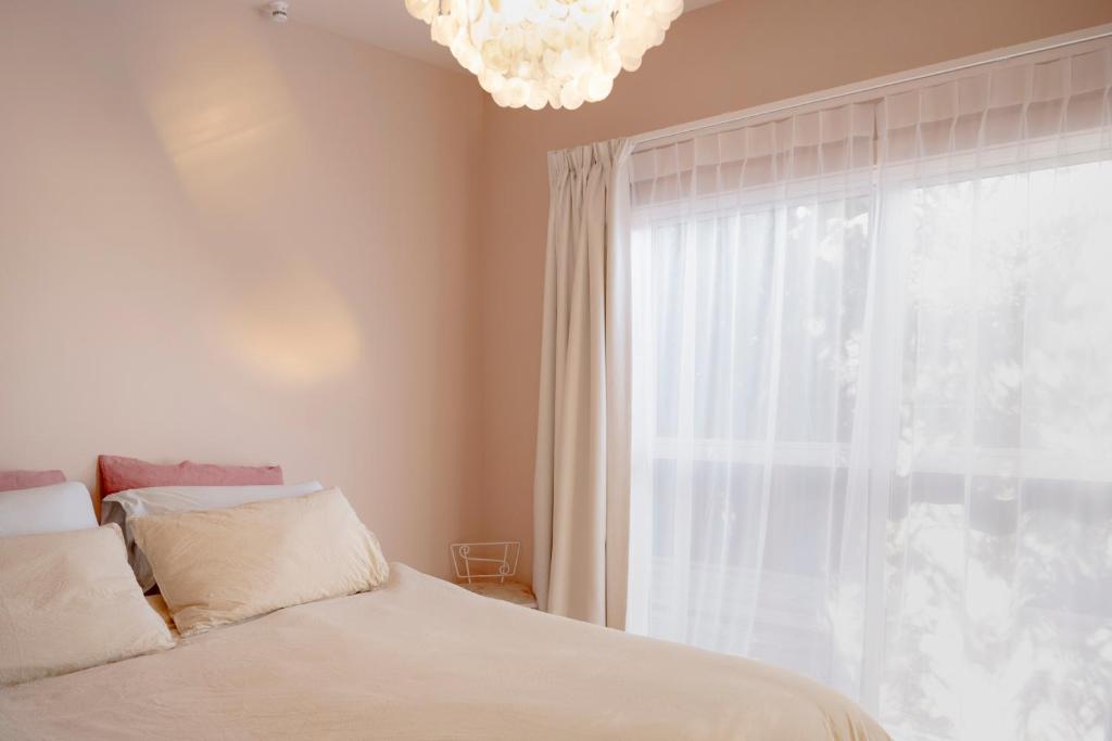 a bedroom with a bed and a window with a chandelier at The Castle in Greytown