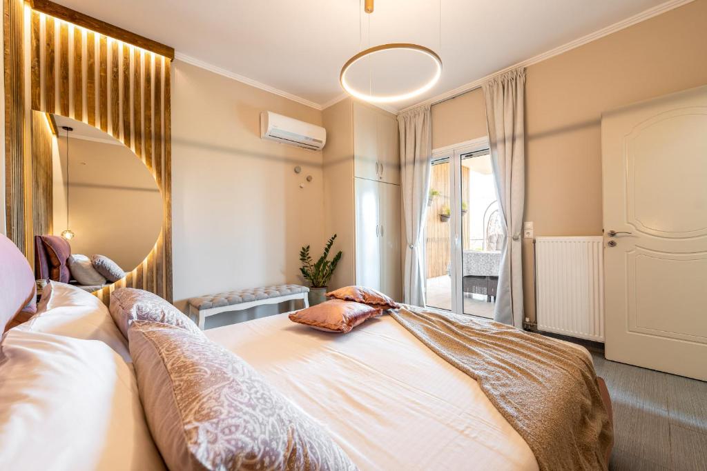een slaapkamer met een groot bed en een spiegel bij Meltemi Beach House - a seaside Luxury maisonnette in Dhiyeliótika