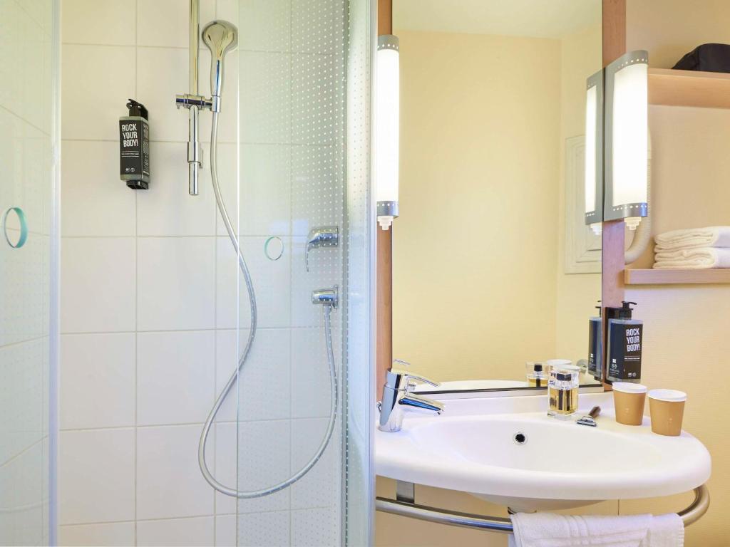 une salle de bain avec douche et lavabo dans l'établissement ibis Paris La Villette Cité des Sciences 19ème, à Paris