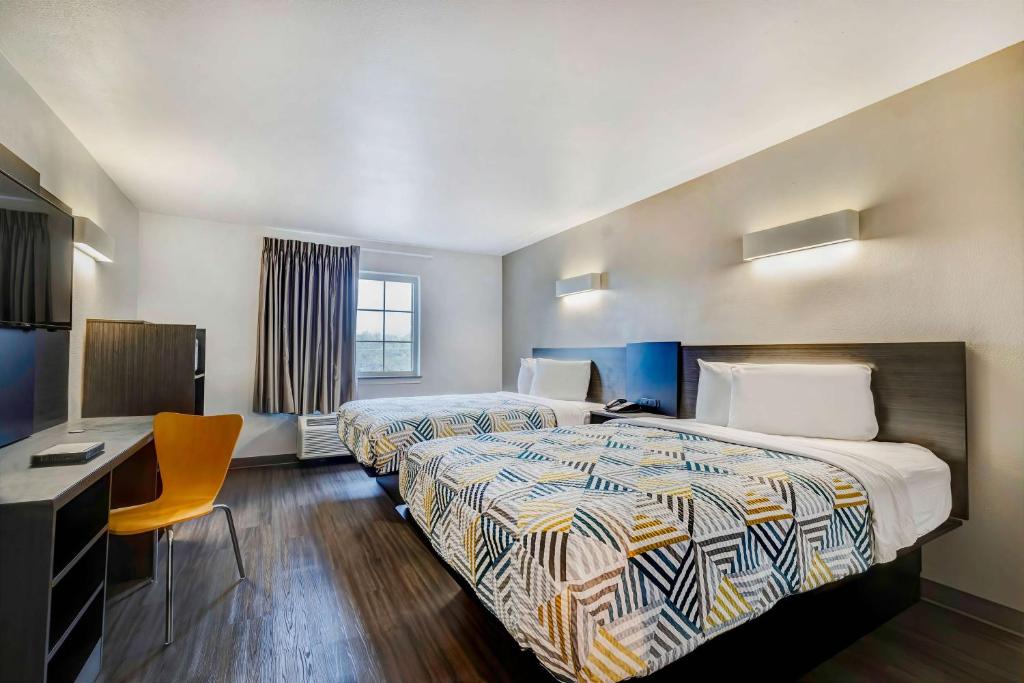 a hotel room with two beds and a desk at Motel 6-Mesquite, TX - Balch Springs in Balch Springs