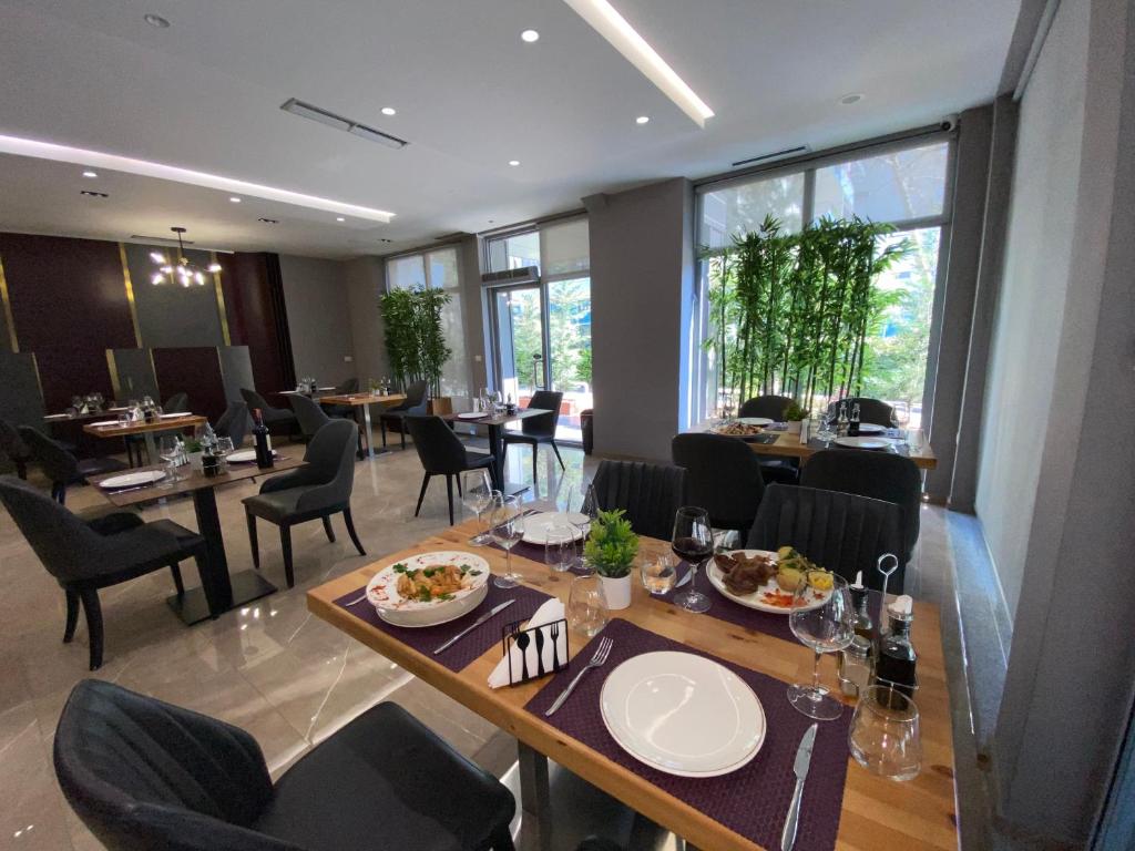 a dining room with tables and chairs with food on them at Doanesia Premium Hotel & Spa in Tirana