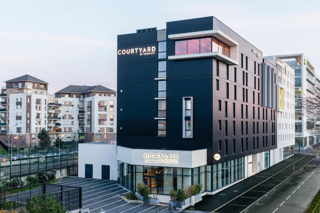 un bâtiment noir avec un panneau sur son côté dans l'établissement Courtyard by Marriott Paris Creteil, à Créteil