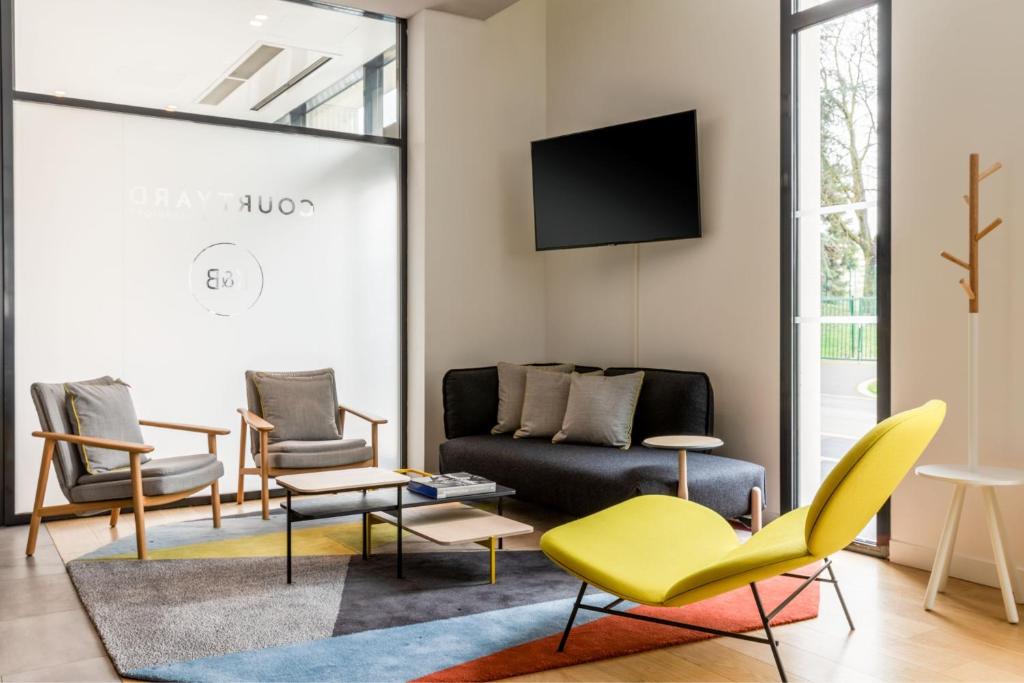 a living room with a couch and chairs at Courtyard by Marriott Paris Creteil in Créteil