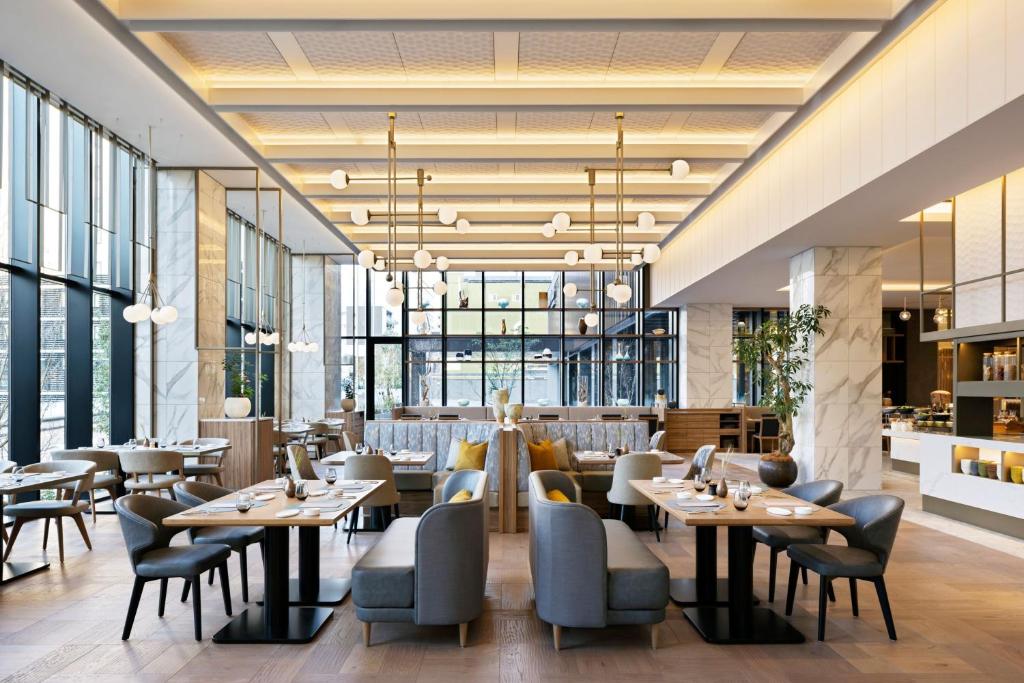 un restaurante con mesas, sillas y ventanas en Courtyard by Marriott Nagoya, en Nagoya