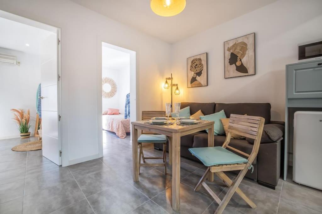 a living room with a table and chairs and a couch at Apartamento Al Alba in Córdoba