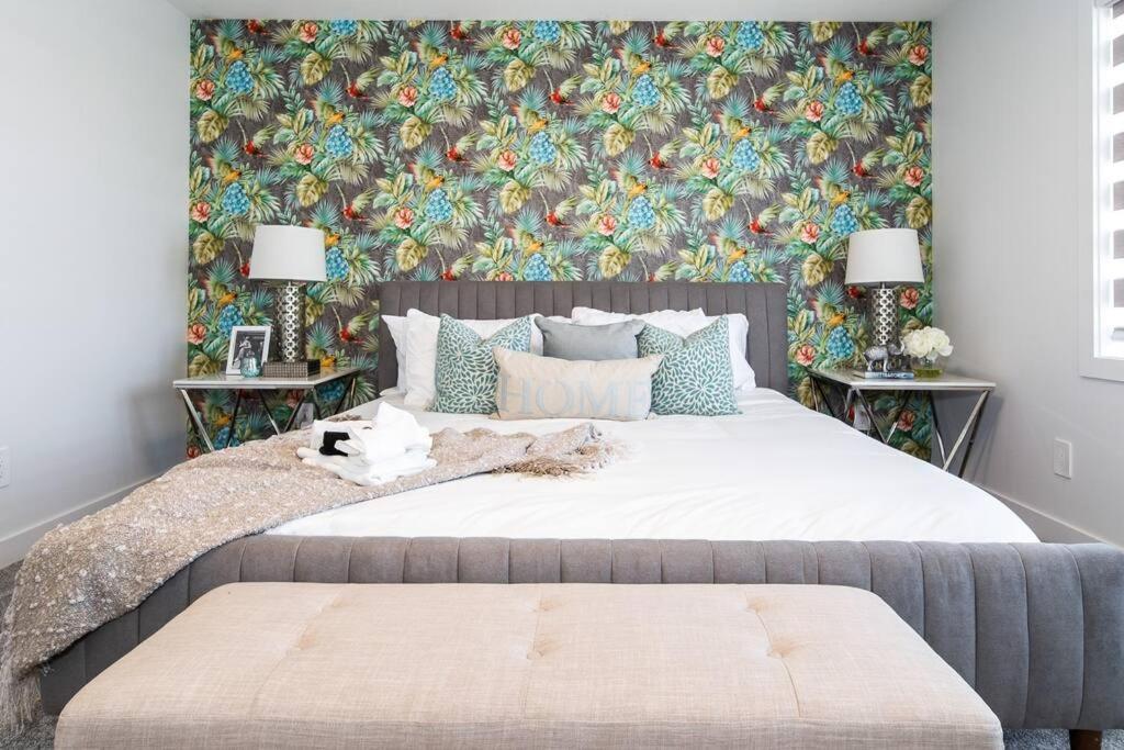 a bedroom with a large bed with a floral wallpaper at *New*Chic Modern Home*King bed*Foosball*Sleeps 8! in Edmonton
