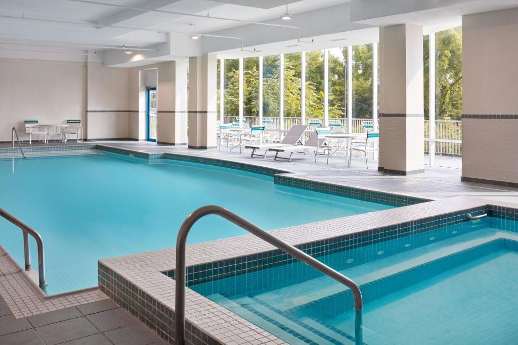 uma piscina num hotel com mesas e cadeiras em Niagara Falls Marriott Fallsview Hotel & Spa em Cataratas do Niágara