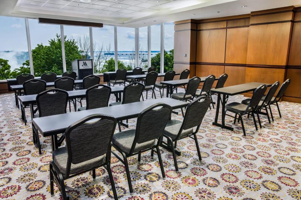 uma fila de mesas e cadeiras num quarto com janelas em Niagara Falls Marriott Fallsview Hotel & Spa em Cataratas do Niágara