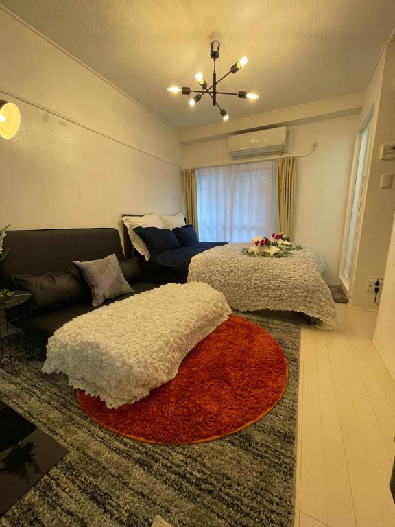 1 dormitorio con 2 camas y sofá en BEST LOCATED SHINJUKU CENTRAL Full-Furnished APARTMENT 3minWalk to Station2, en Tokio