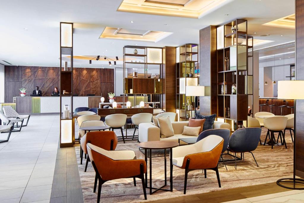 a lobby of a hotel with chairs and tables at London Marriott Hotel Regents Park in London