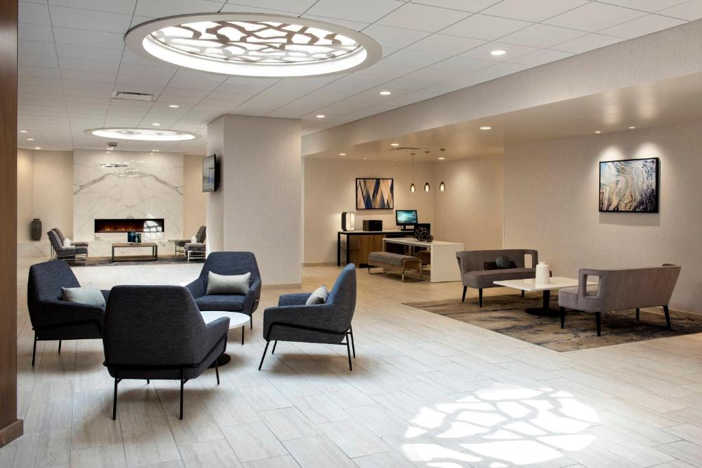 una sala de espera con sillas, un sofá y una mesa en Delta Hotels by Marriott Utica en Utica