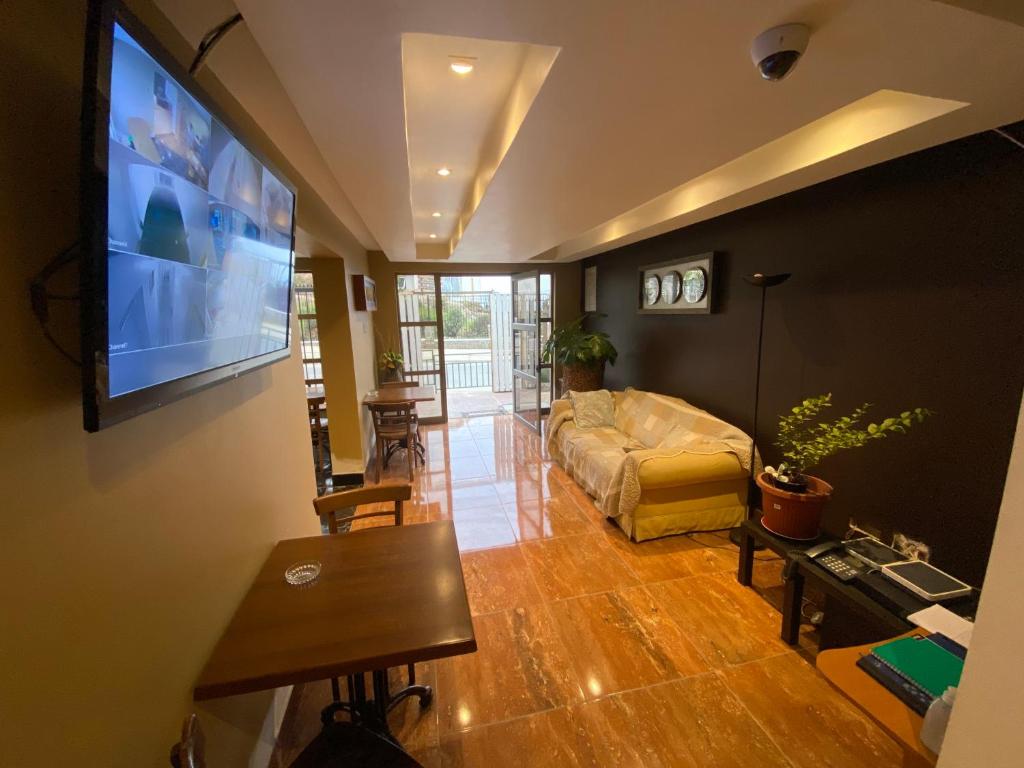 uma sala de estar com um sofá e uma televisão de ecrã plano em AH Rent em Quintero
