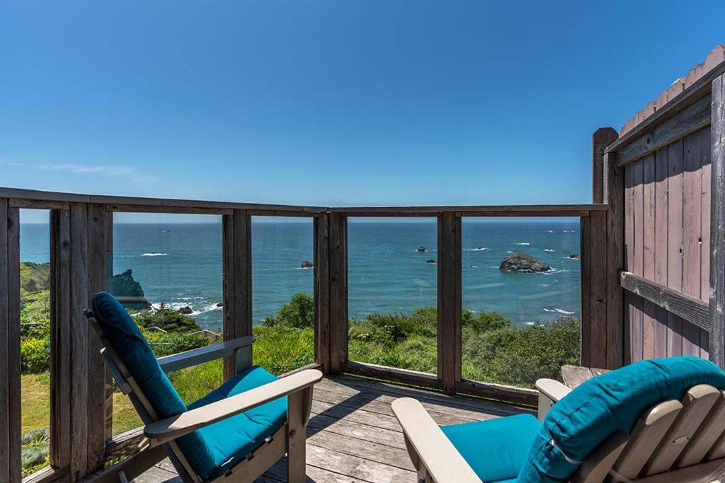 a deck with two chairs and a view of the ocean at Turtle Rocks Oceanfront Inn in Trinidad