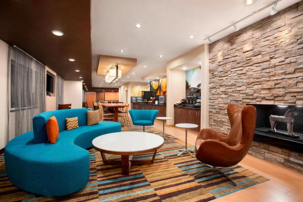 a living room with blue furniture and a fireplace at Fairfield Inn & Suites Minneapolis-St. Paul Airport in Mendota Heights