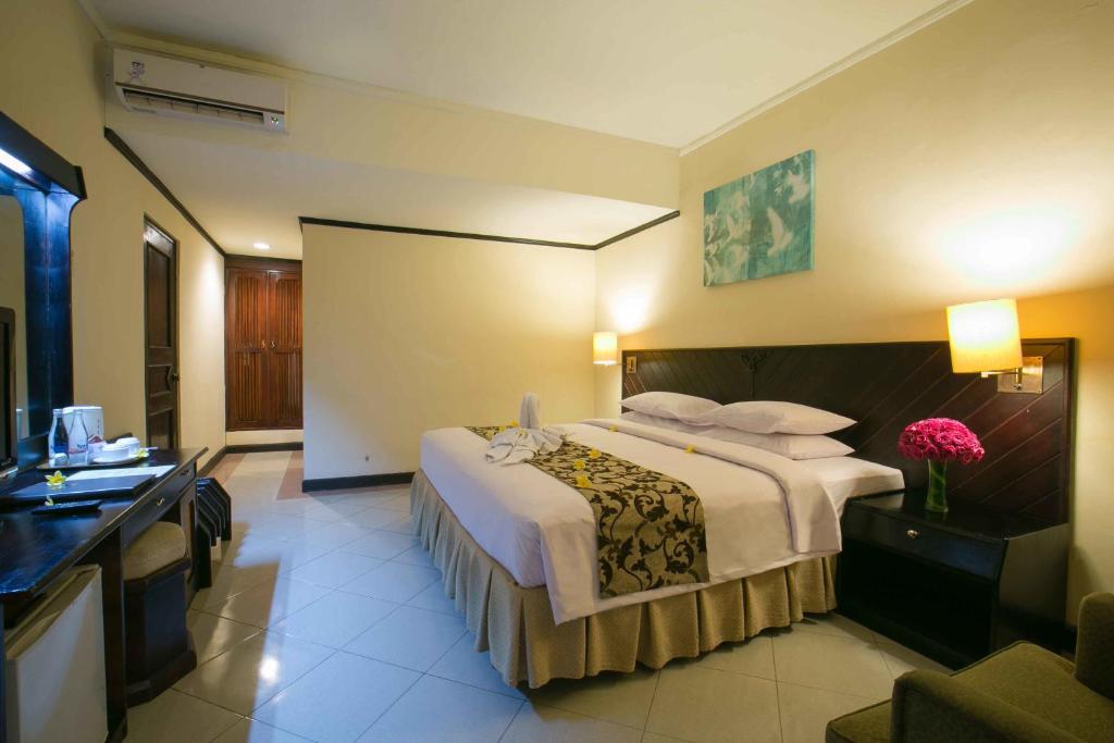 Postel nebo postele na pokoji v ubytování Legian Paradiso Hotel