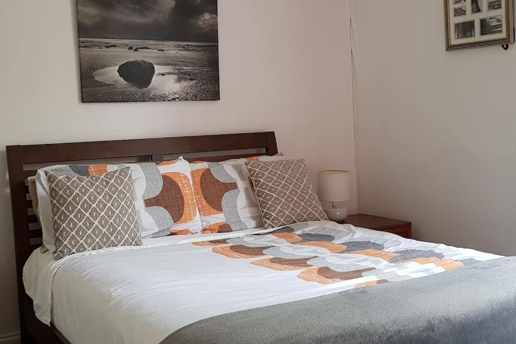 1 dormitorio con 1 cama grande con sábanas y almohadas blancas en Nice Central Flat Walk to Princes StreetRoyal Mile, en Edimburgo