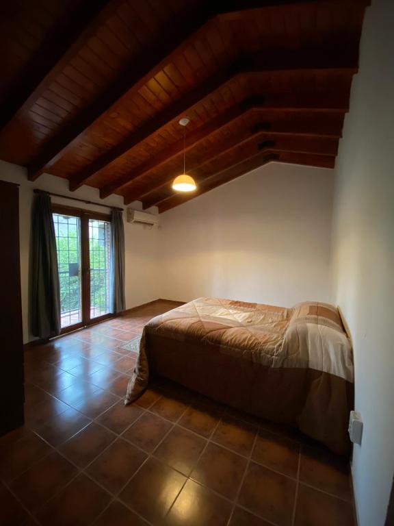 um quarto com uma cama num quarto com uma janela em HUILEN REST em Luján de Cuyo