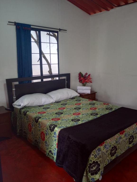 - une chambre avec un lit et une fenêtre dans l'établissement La Flor de Jalisco, à Calarcá