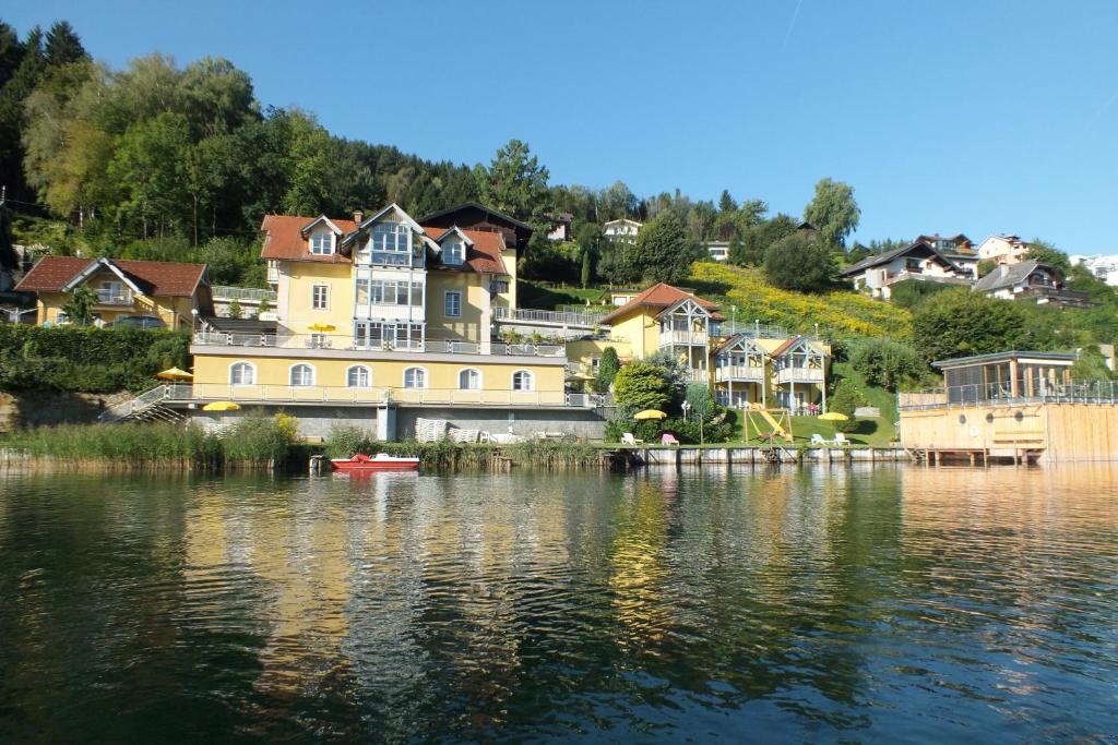 eine Gruppe von Häusern am Ufer eines Sees in der Unterkunft Appartements-Strandschlößl Heitzmann in Seeboden