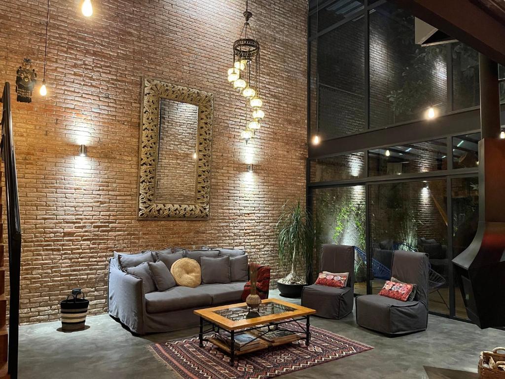 a living room with a couch and a brick wall at Mi Refugio San Angel in Mexico City