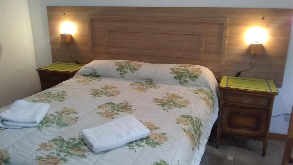 ein Bett mit zwei Nachttischen und zwei Handtüchern darauf in der Unterkunft Mi Lugar in Olavarría