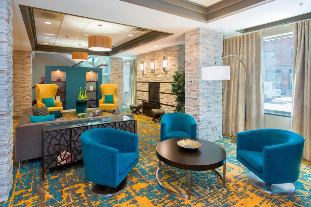 a hotel lobby with blue chairs and a table at Residence Inn by Marriott Moncton in Moncton