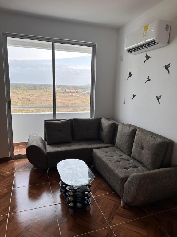 een woonkamer met een bank en een raam bij Apartamento nuevo en Coveñas in Coveñas