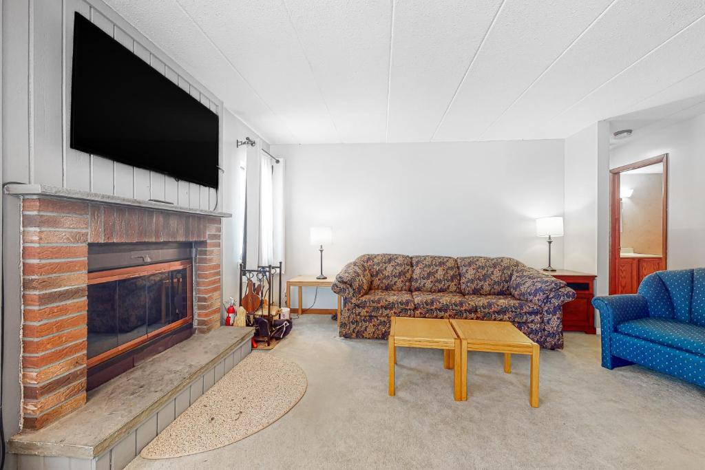 a living room with a tv and a couch and a fireplace at Mountain Village 5H Unit A in Dover