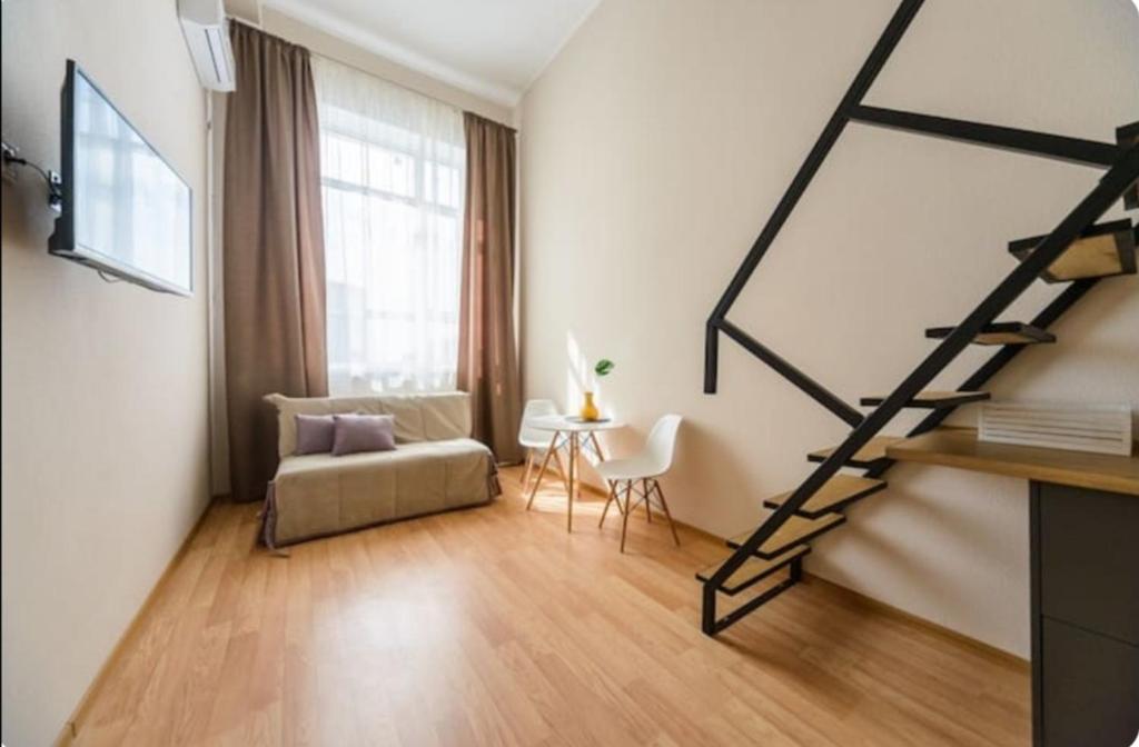 een woonkamer met een trap en een bank bij Cozy SmartHouse in Kiev