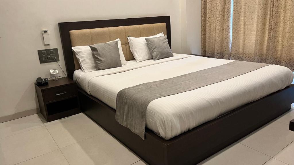1 dormitorio con 1 cama grande y cabecero de madera en K Plus Comforts, en Kārwār