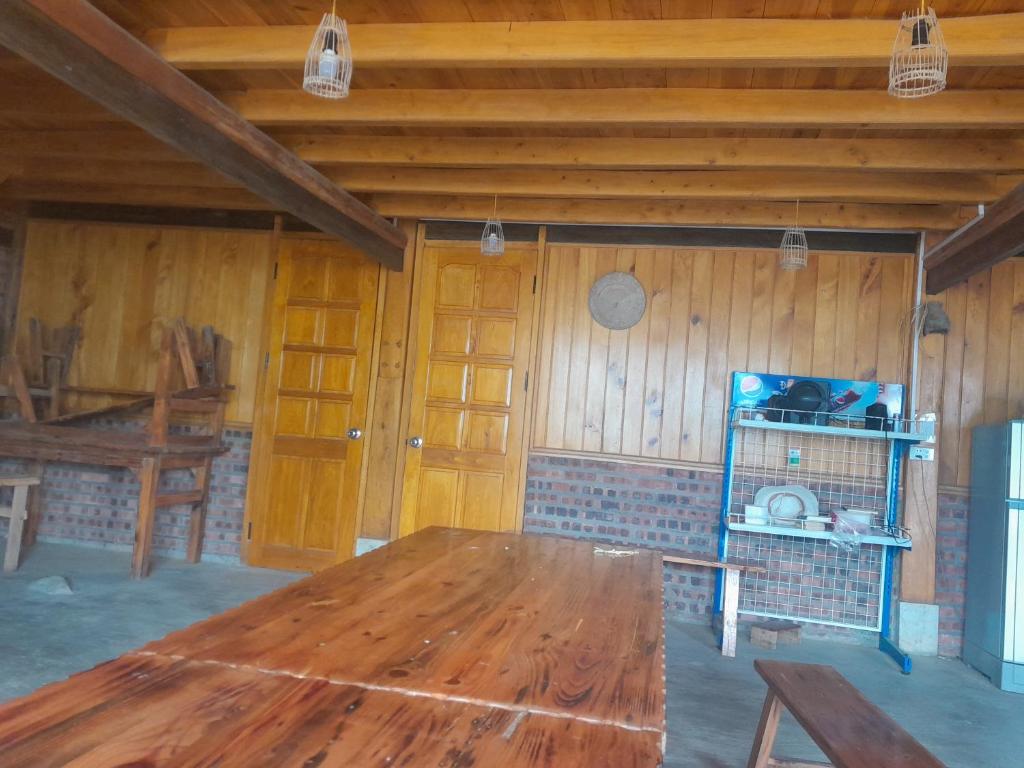 a large room with a wooden table and a kitchen at Tee Homestay hmong and trekking in Lao Cai