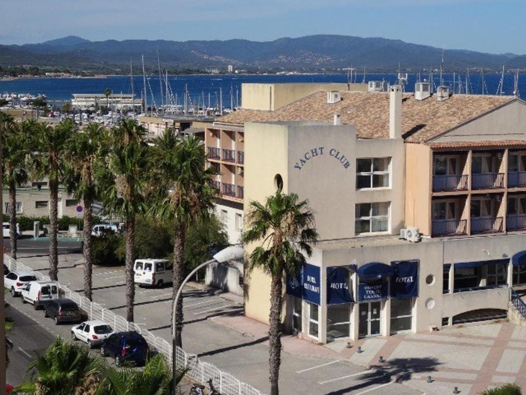 un hôtel avec des palmiers devant un bâtiment dans l'établissement Appartement à Hyères avec parking, véranda et cuisine équipée - FR-1-335-177, à Hyères
